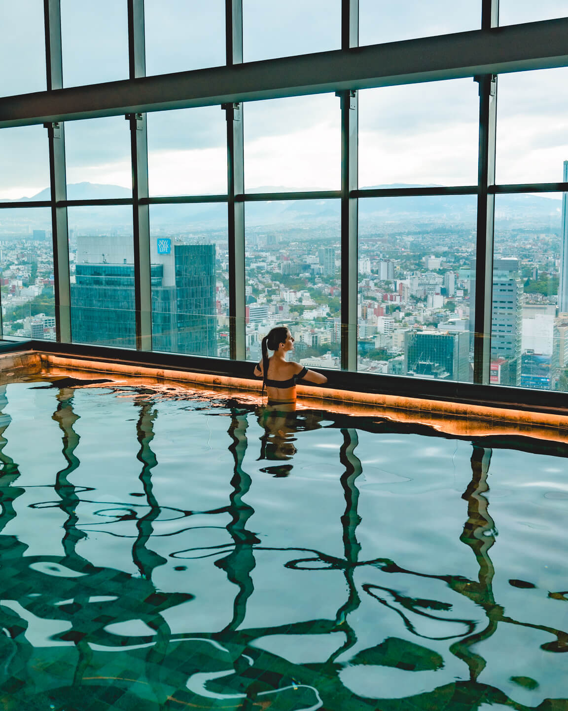 girl overlooking Mexico City from indoor pool