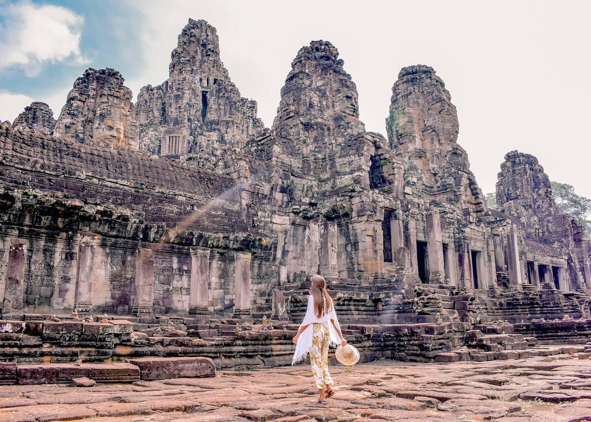 girl walking in front of temple ruins in Angkor