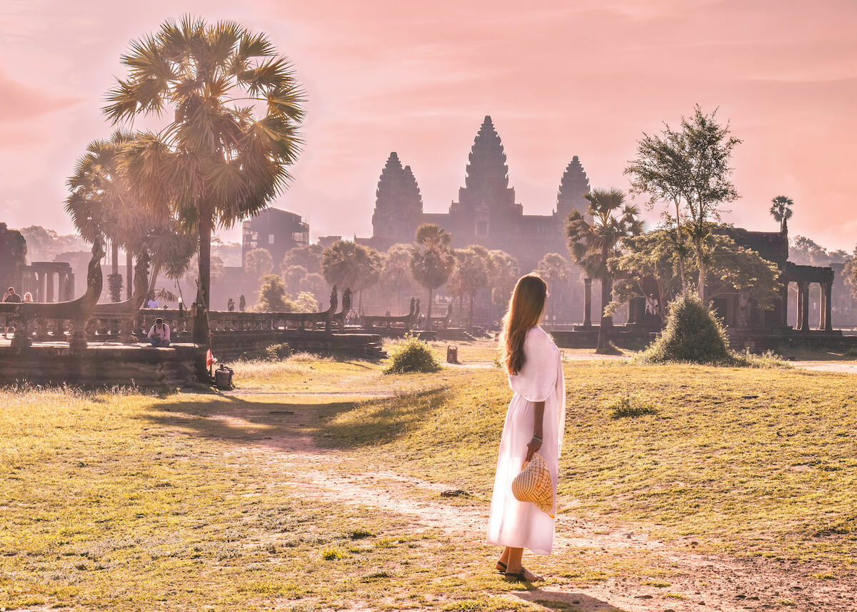 girl watching the sunrise behind Angkor Wat in Cambodia